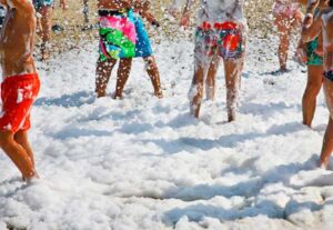 Grupo de amigos disfruta de una fiesta de espuma en verano