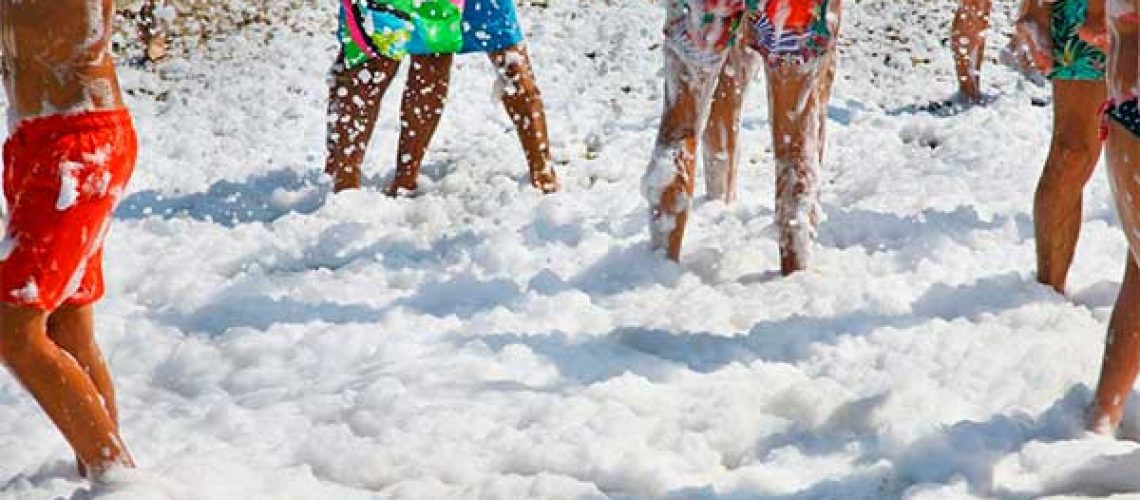 Grupo de amigos disfruta de una fiesta de espuma en verano